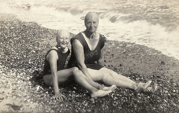 Mother and daughter in swimsuits and bathing caps