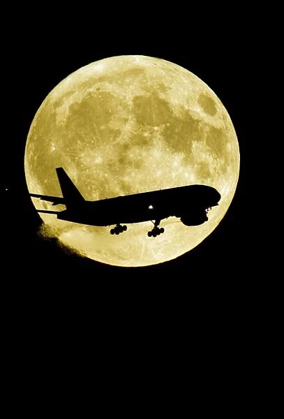 Aeroplane silhouetted against a full moon