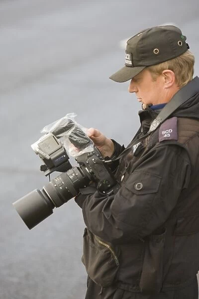 A police photographer photographing protestors at the Climate camp protest against airport development at Heathrow and the village of Sipson that would be demolished to make place for a third