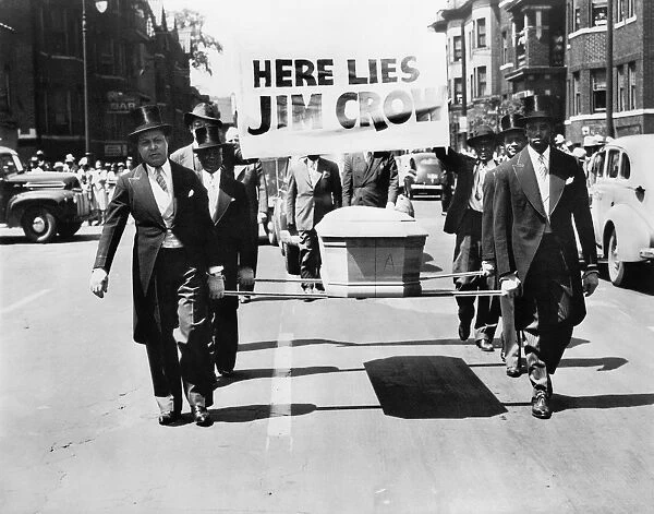 Pallbearers with a casket walking in front of a sign reading Here Lies Jim Crow, during the Parade for Victory, sponsored by the Detroit branch of the National Association for the Advancement of Colored People, 1944