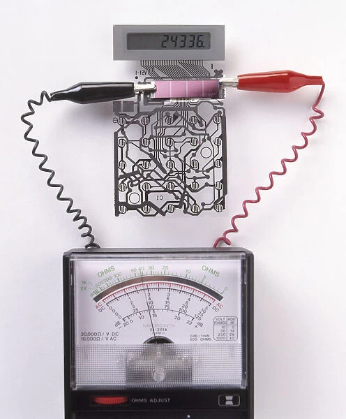 A solar cell inside a calculator connected to a a multimeter, measuring the electricity generated