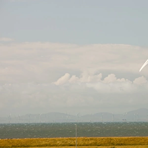 An onshore wind turbine on the outskirts of Workington, Cumbria, UK. In the background is the new Robin Rigg offshore wind farm in the Solway Firth. Robin Rigg is one of the largest wind farms in the UK. It is operated by E. on and consists of 60, 3