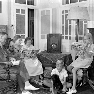 FAMILY, 1930s. A family in Jerusalem seated around a radio, reading. Photographed between 1937