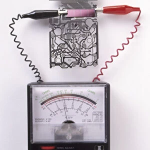 A solar cell inside a calculator connected to a a multimeter, measuring the electricity generated