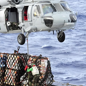 U. S. Sailors connect a cargo pendant to an MH-60S Seahawk helicopter
