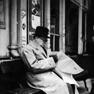 British Prime Minister Winston Churchill reading a newspaper on the platform at St
