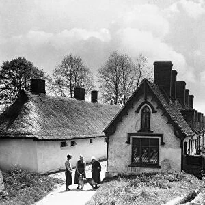 Pretty almshouses and 19th century windmill at Thaxted, North Essex. Circa 1935
